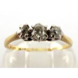 A diamond three stone ring, the three graduated mine cuts claw set above a yellow metal shank,