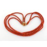 A three strand coral necklace, composed of three strands of graduated spherical beads, to a bolt