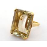 An 18 carat gold and citrine dress ring, the large rectangular step cut stone approx. 37 carats, the