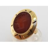 A carnelian intaglio dress ring, the oval intaglio cut as a stylised head in profile, to pierced and