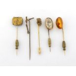 A collection of stickpins, including a Victorian articulated skeleton, a Georgian mourning pin, a