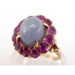A star sapphire and ruby cluster ring, the high domed grey/blue star sapphire, in a surround of