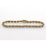 A 9 carat gold and diamond line bracelet, composed of cross stitch links, with illusion set