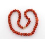 A coral bead necklace, composed of uniform flattened barrel beads, each approx. 9.5mm diameter, to a