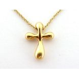 TIFFANY & Co., 'Elsa Peretti Collection', an 18 carat gold cross pendant, 12mm wide, to an 18