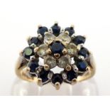 A 9 carat gold and sapphire cluster ring, composed of three tiers of alternate white and blue