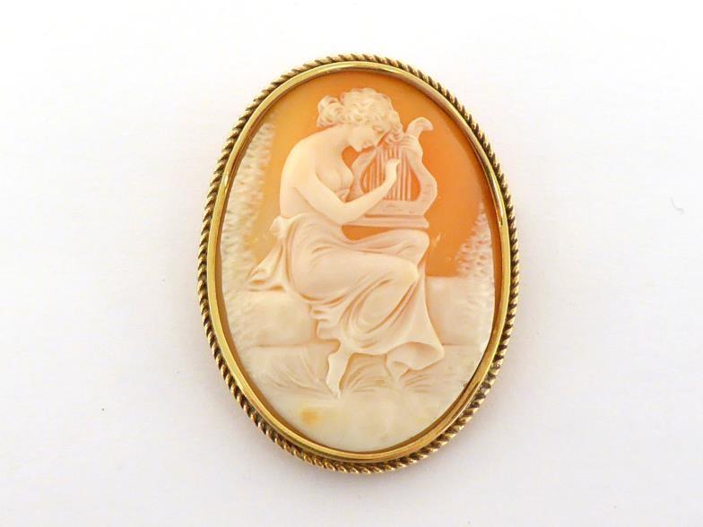 A shell cameo brooch, the large oval cameo depicting Erato, 48mm long, in a gold rope twist