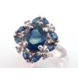 A sapphire and diamond cluster ring, the central oval cut sapphire approx. 2.55 carats, in a