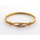 A mid Victorian gold, ruby, diamond and seed pearl Etruscan bangle, the central bird motif set