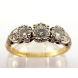 An 18 carat gold and three stone diamond ring, the three illusion set brilliants totalling approx.