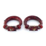 A pair of Indian anklet bangles in white metal with red enamel, the hinged openings with clasps