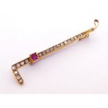 A late 19th century diamond and ruby brooch, modelled as riding crop, set along its length with mine