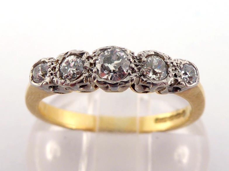 An 18 carat gold and five stone diamond ring, set with five graduated old brilliants totalling