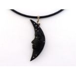 A silver, ebony and opal 'Man in the Moon' pendant by David Hensel, the two sided crescent moon