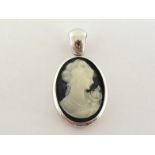 A 1970s resin cameo pendant, the oval cameo depicting a woman with a rose, in an Italian silver