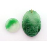 Two jade pendants, including one carved as a tribal mask, 5cm long, and a small bi, 2.6cm diameter