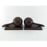 A pair of hardwood bookends, each shaped as a drumstick resting on board. 21x10x10cm.