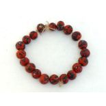 A glass bead necklace, composed of large spherical 35mm diameter red patterned beads, 22cm long
