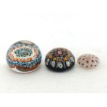 Three millefiori glass paperweights, one large weight with concentric canes, one with latticino