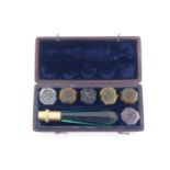 A 19th century boxed set of coloured glass intaglio seals, with handle, 6.5cm long