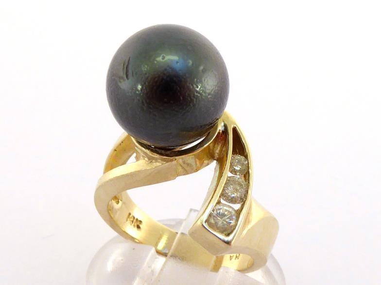 A Tahitian cultured pearl and diamond ring, the large pearl 12.3mm diameter, obliquely set, the tail