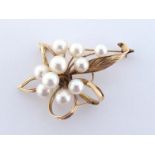 A cultured pearl spray brooch, the cluster of ten 5-7mm pearls above a open work flower mount,