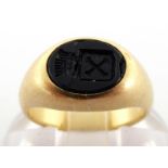 A child's signet ring, the small oval onyx intaglio cut with a coat of arms, the shank stamped '