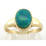 A synthetic opal ring, the oval stone 10 x 7mm, the shank stamped '585', finger size W, 3.3gms