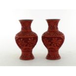 A pair of Chinese carved lacquer vases, floral design on the red lacquered body, two oval panels