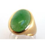A jade ring, the large jade cabochon 19 x 13mm, rub over set, the shank stamped '14k', finger size