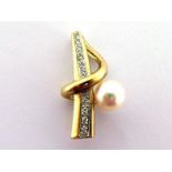 A cultured pearl and diamond pendant, the round pearl 7.6mm, off set against a row of graduated