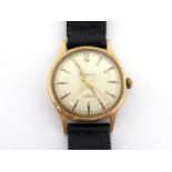 A 1950s 9 carat gold gentleman's manual wind wrist watch, the circular silvered dial signed '