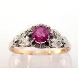A ruby and diamond ring, the central round cut ruby 4.6mm, claw set above illusion set diamond