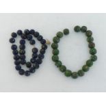 Two glass bead necklaces, composed of spherical green and blue patterned beads, 28 and 32 cm long