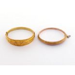 Two mid- Victorian gold bangles, the first with finely chased foliate scrolls, to a beaded border,