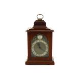 A mahogany cased reproduction mantel clock in the 18th. century manner, the dial with silvered
