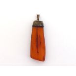 An amber pendant, the blade like amber with two insecct inclusions, 6cm long, to a textured yellow