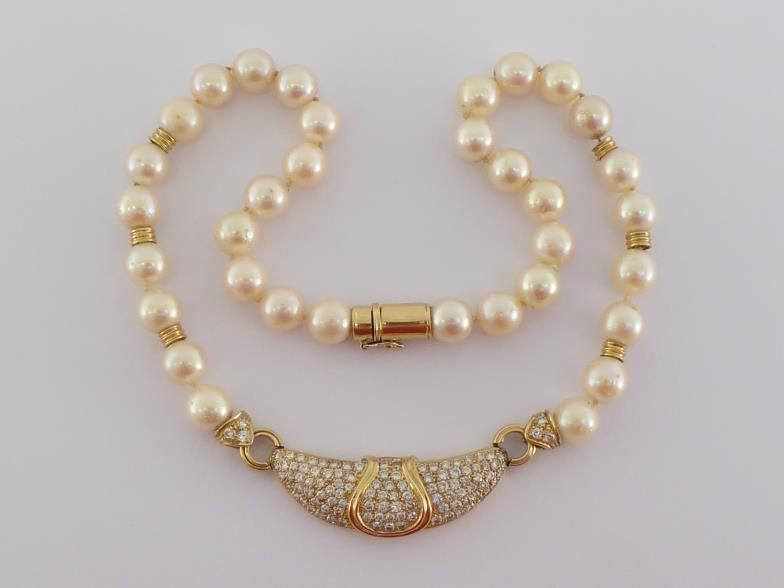 A yellow metal (tests 18 carat gold), diamond and cultured pearl necklace, the central elongated