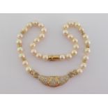 A yellow metal (tests 18 carat gold), diamond and cultured pearl necklace, the central elongated