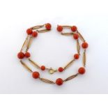 A coral bead necklace, the graduated spherical 6.8-10mm beads with gold navette shaped spacers,