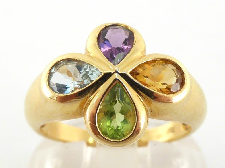 A French 18 carat and multi gem ring, the quatrefoil bezel rub over set with a pear cut amethyst,