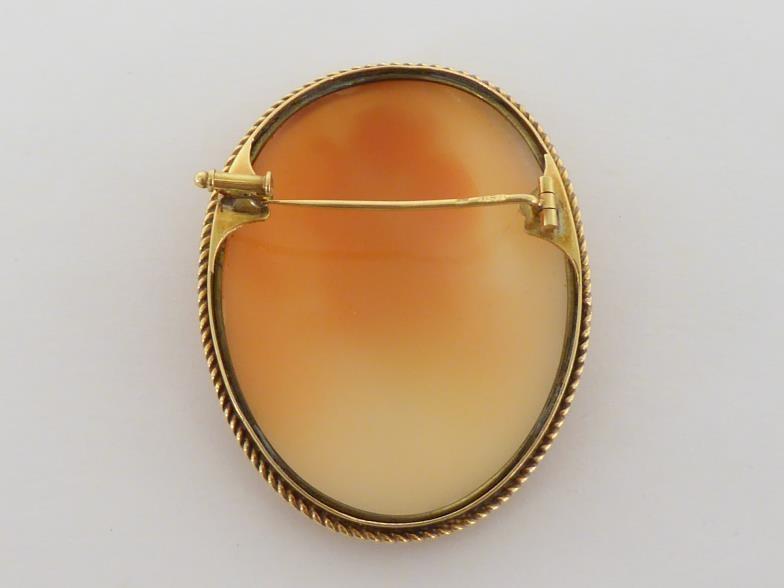 A shell cameo brooch, the large oval cameo depicting Erato, 48mm long, in a gold rope twist - Image 2 of 4