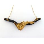 A gold, diamond and black coral necklace by Nele, the central motif of a mask below laurel set