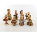 A group of seven Hummel figurines of children.