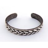 A Zimbabwean "C"-shaped silver bangle with English import marks by Patrick Mavros, 1972, applied
