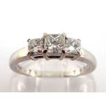 A three stone diamond ring, the three graduated princess cut stones totalling approx. 0.75 carat,