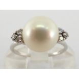 A cultured pearl and diamond ring, the central round pearl 8.5mm diameter, to a trefoil of