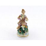 A small ceramic scent bottle very well modelled as a lady seated on a leafy mound, her head the