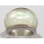 A diamond and mother of pearl dress ring, the large facetted crystal bezel overlaying the mother-