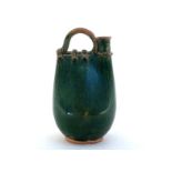 A large green glazed water carrier formed as a leather vessel with short upright circular spout
